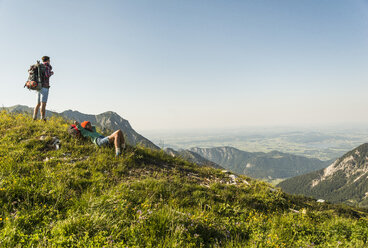 Österreich, Tirol, Tannheimer Tal, junges Paar rastet auf Almwiese - UUF005102