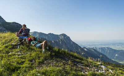 Austria, Tyrol, Tannheimer Tal, young couple resting on alpine meadow - UUF005103