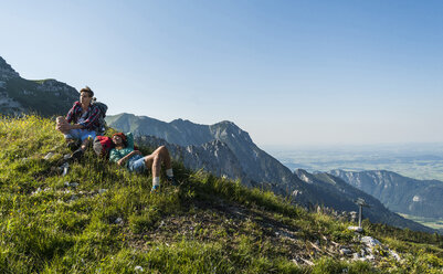 Österreich, Tirol, Tannheimer Tal, junges Paar rastet auf Almwiese - UUF005103