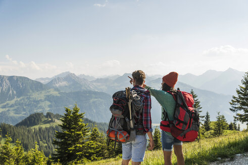Österreich, Tirol, Tannheimer Tal, junges Paar in alpiner Landschaft mit Blick auf die Aussicht - UUF005106