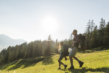 Austria, Tyrol, Tannheimer Tal, young couple hiking on alpine meadow - UUF005111