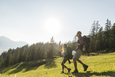 Österreich, Tirol, Tannheimer Tal, junges Paar wandert auf Almwiese - UUF005111