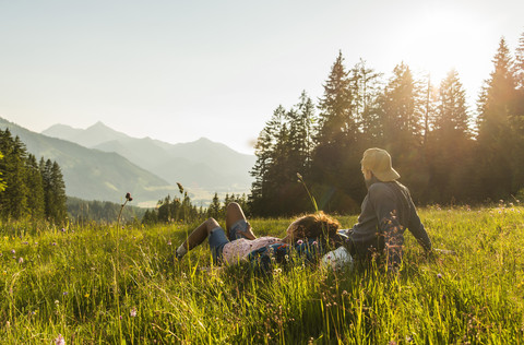 Austria, Tyrol, Tannheimer Tal, young couple resting on alpine meadow stock photo
