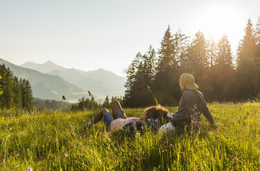 Austria, Tyrol, Tannheimer Tal, young couple resting on alpine meadow - UUF005114