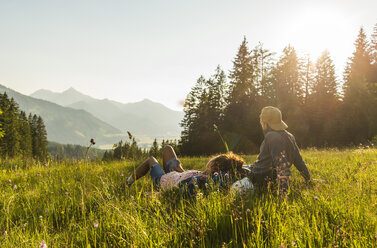 Österreich, Tirol, Tannheimer Tal, junges Paar rastet auf Almwiese - UUF005114