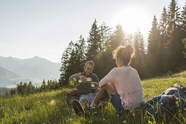 Österreich, Tirol, Tannheimer Tal, junges Paar rastet auf Almwiese - UUF005117