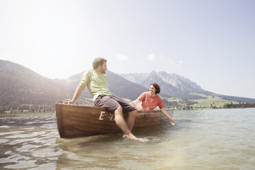 Austria, Tyrol, couple relaxing on a boat on Walchsee - RBF002987