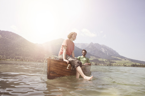 Österreich, Tirol, Paar entspannt auf einem Boot auf dem Walchsee, lizenzfreies Stockfoto