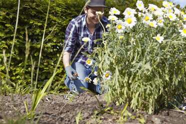 Lächelnder Mann bei der Arbeit im Garten - RHF000999