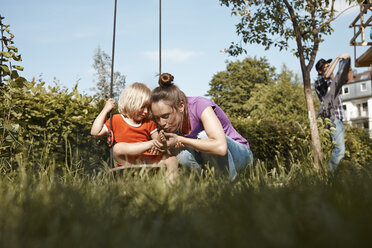 Mother caring for injured daughter in garden - RHF001008