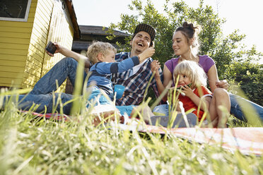 Glückliche Familie entspannt sich im Garten - RHF001009