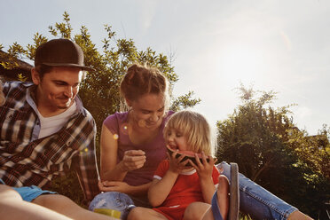 Happy family relaxing in garden - RHF001035