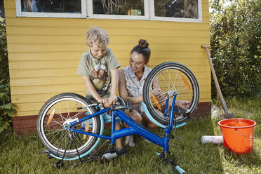 Mutter und Sohn reparieren gemeinsam ihr Fahrrad - RHF001025