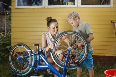 Mutter und Sohn reparieren gemeinsam ihr Fahrrad - RHF001026