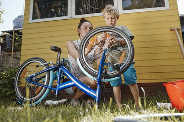 Mutter und Sohn reparieren gemeinsam ihr Fahrrad - RHF001027