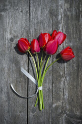 Strauß roter Tulpen auf grauem Holz - CRF002705