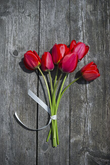 Strauß roter Tulpen auf grauem Holz - CRF002705