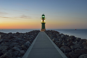 Deutschland, Warnemünde, Blick auf Leuchtturm in der Abenddämmerung vor der Ostsee - RJF000466