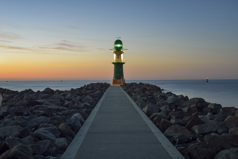 Germany, Warnemuende, view to lighthouse at dusk in front of the Baltic Sea - RJF000466