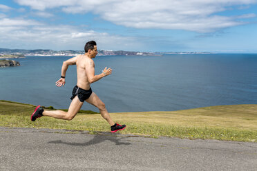 Shirtless man jogging at the coast - MGOF000368