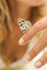 Schmetterling auf der Hand einer Frau - TCF004776