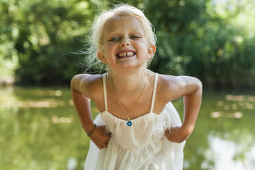 Portrait of blond girl with wet dress at a lake - TCF004785