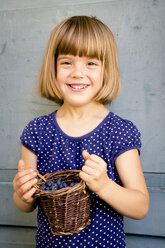 Porträt eines kleinen Mädchens mit einem Weidenkorb voller Blaubeeren - LVF003737