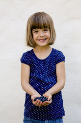 Portrait of little girl with two handfuls of blueberries - LVF003751