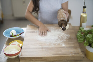 Young woman preparing pizza dough in kitchen - RIBF000188