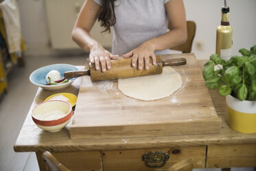 Young woman preparing pizza dough in kitchen - RIBF000193