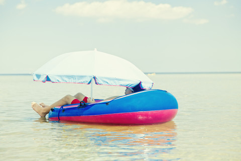 Germany, Niendorf, young boy relaxing in an inflatable boat stock photo