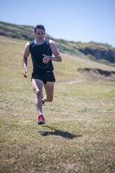 Spain, Asturias, Gijon, Athlete training outdoors, doing roadwork - MGOF000373