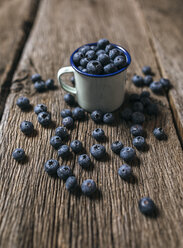 Enamel cup of blueberries on wood - MGOF000383