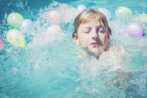 Junge im Schwimmbad, umgeben von Luftballons - SARF002071