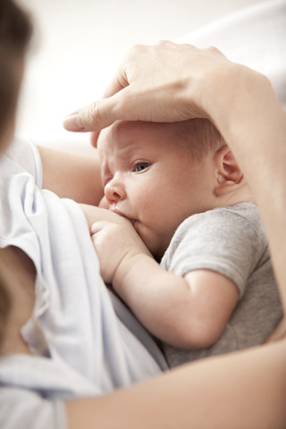 Junge Frau, die ihr Baby stillt, lizenzfreies Stockfoto