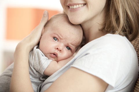 Portrait of baby in mother's arms stock photo