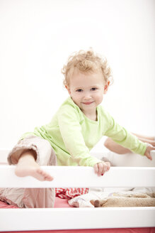 Porträt eines kleinen blonden Mädchens im Kinderbett stehend - MFRF000304
