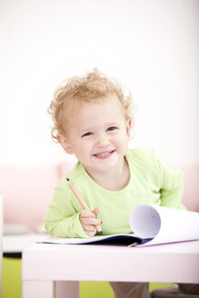 Porträt eines grinsenden kleinen blonden Mädchens mit Farbstift - MFRF000305