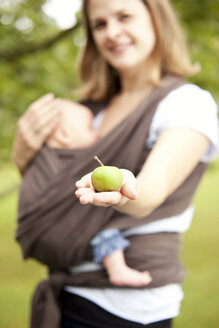 Mutter mit kleinem Mädchen hält Apfel in der Hand - MFRF000318