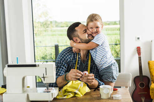 Happy daughter cuddling father at home - UUF005145