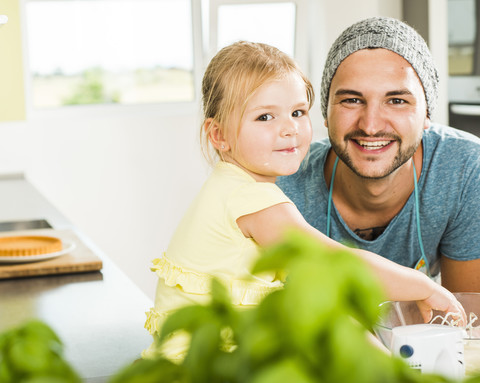 Porträt von lächelndem Vater und Tochter beim Backen in der Küche, lizenzfreies Stockfoto