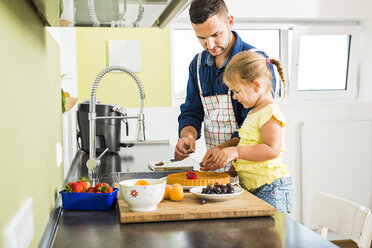 Vater und Tochter in der Küche bei der Zubereitung von Obstkuchen - UUF005181