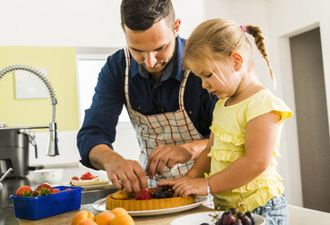 Vater und Tochter in der Küche bei der Zubereitung von Obstkuchen - UUF005185
