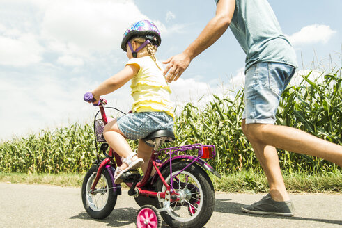 Father accompanying daughter on bike - UUF005199