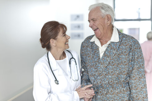 Arzt mit glücklicher älterer Patientin auf dem Krankenhausflur - ZEF007235
