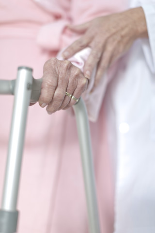 Älterer Patient mit Gehhilfe wird gestützt, lizenzfreies Stockfoto