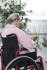 Elderly patient in wheelchair using digital tablet - ZEF007242