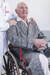 Doctor and smiling elderly patient in wheelchair - ZEF007251