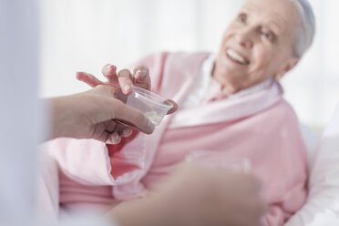 Patient lying in hospital bed receiving medication - ZEF007263