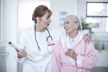 Doctor and smiling elderly patient on hospital floor - ZEF007255